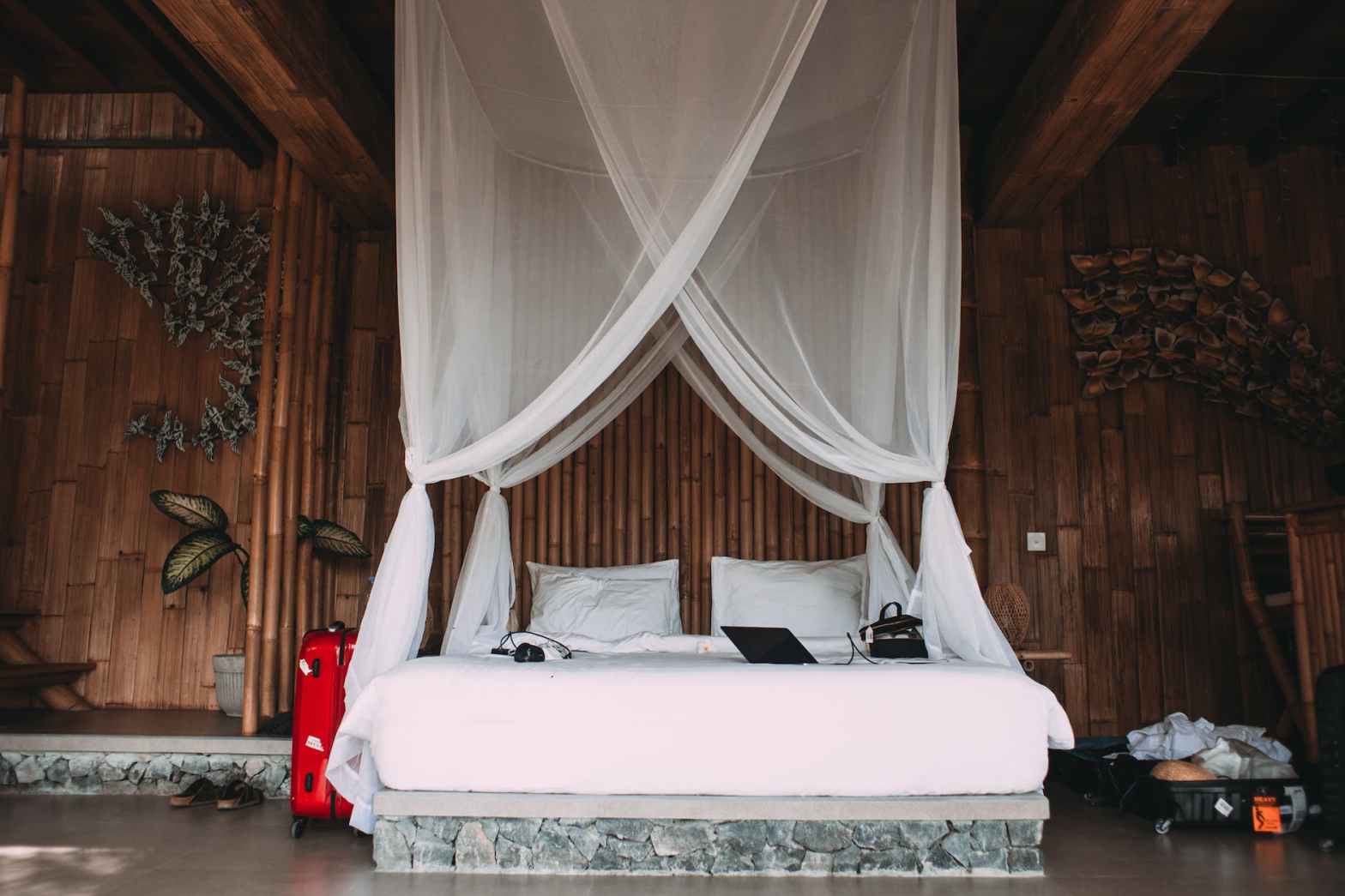 cozy hotel bed with laptop under canopy